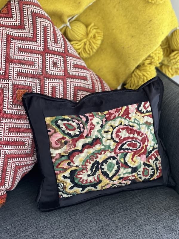 cushion featuring tapestry with paisley pattern on a grey lounge with yellow blanket