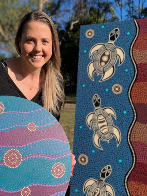 Caitlin Trindall with indigenous artwork
