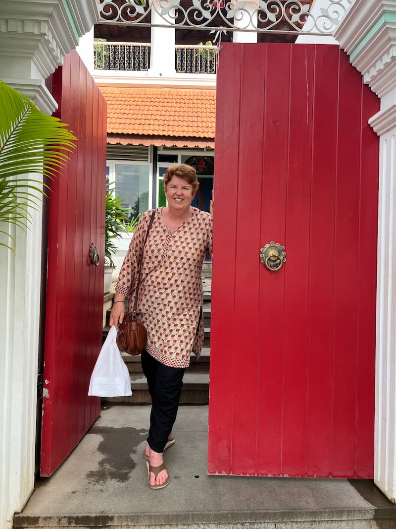 Tour guide Nicole standing in front of a large red door