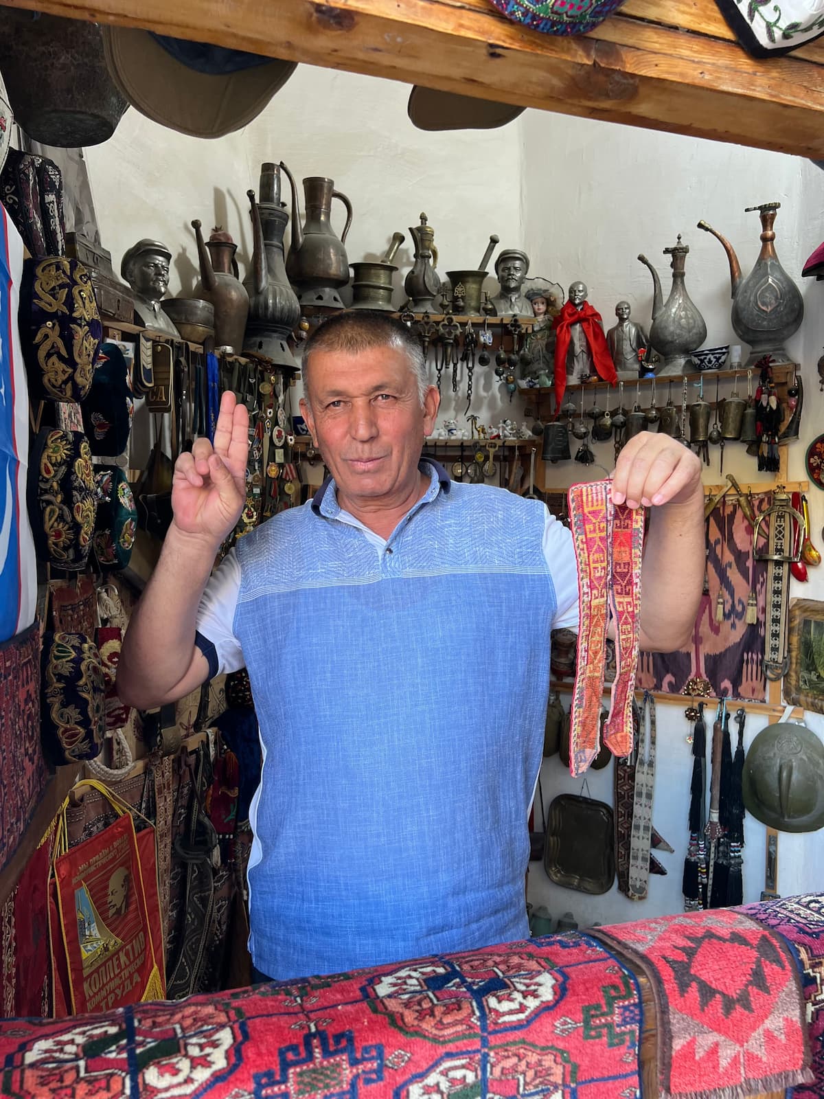 man in market stall holding fabric